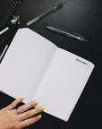 Creative planner opened to the brainstorm page, sitting alongside some pens and a ruler.