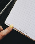 Artistic shot of a finger touching the open page of the planner that reads - this idea freaking rocks