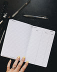 Creative planner opened to the project page sitting alongside some pens and a ruler.