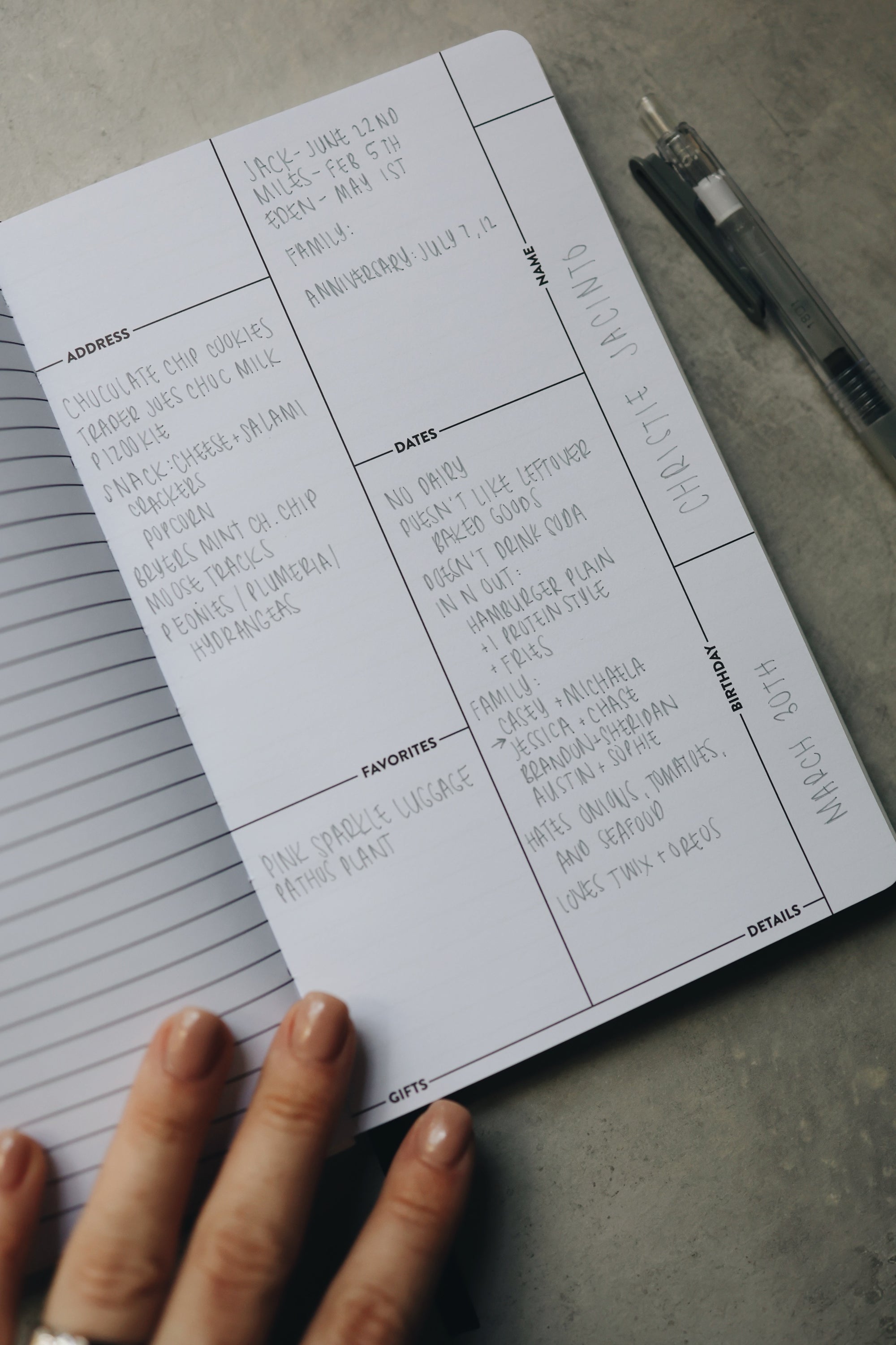 A hand holding the friendship journal open with handwriting on the page.