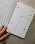A hand holding the friendship journal open.