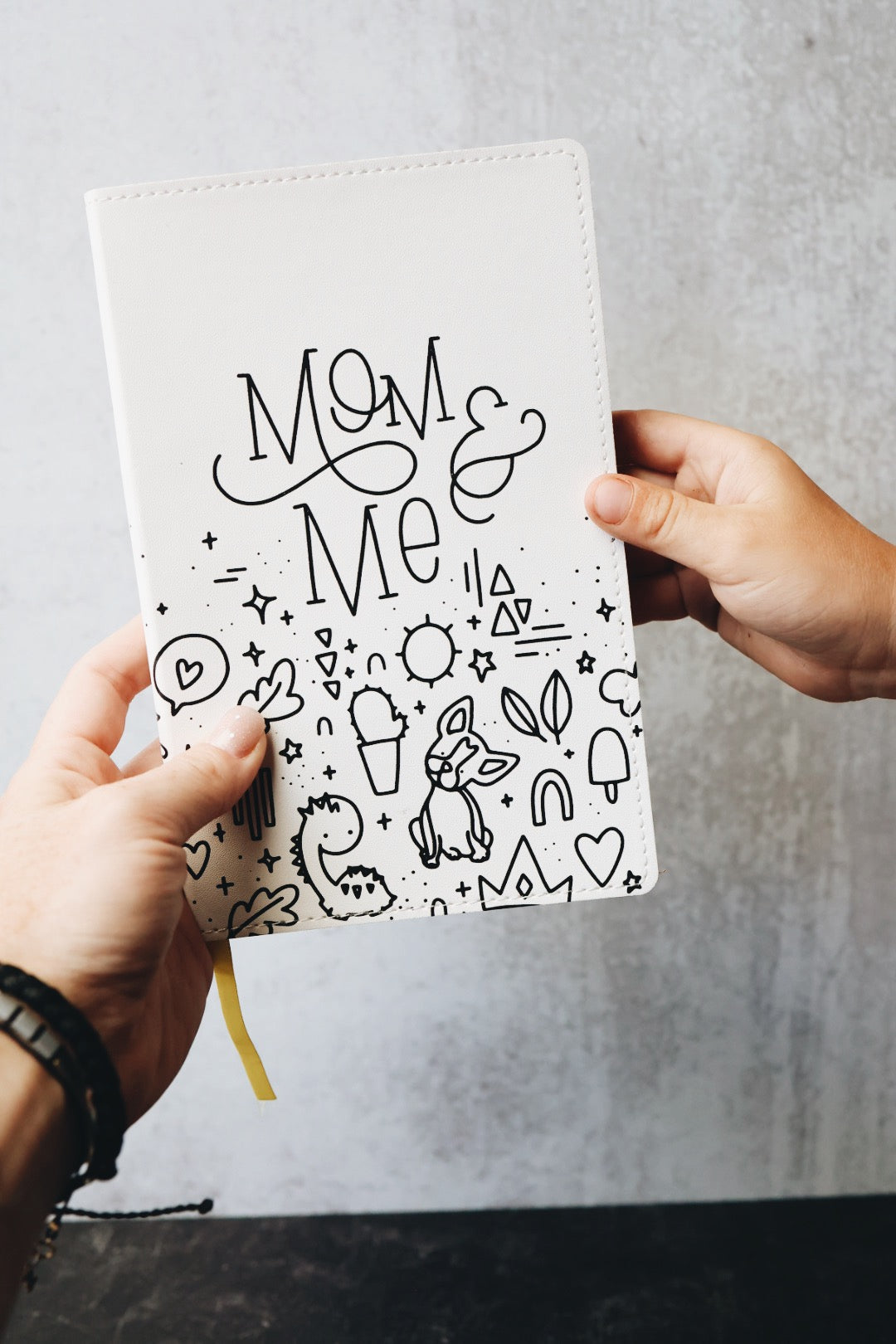 Two hands holding the mom & me journal