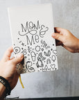 Two hands holding the mom & me journal
