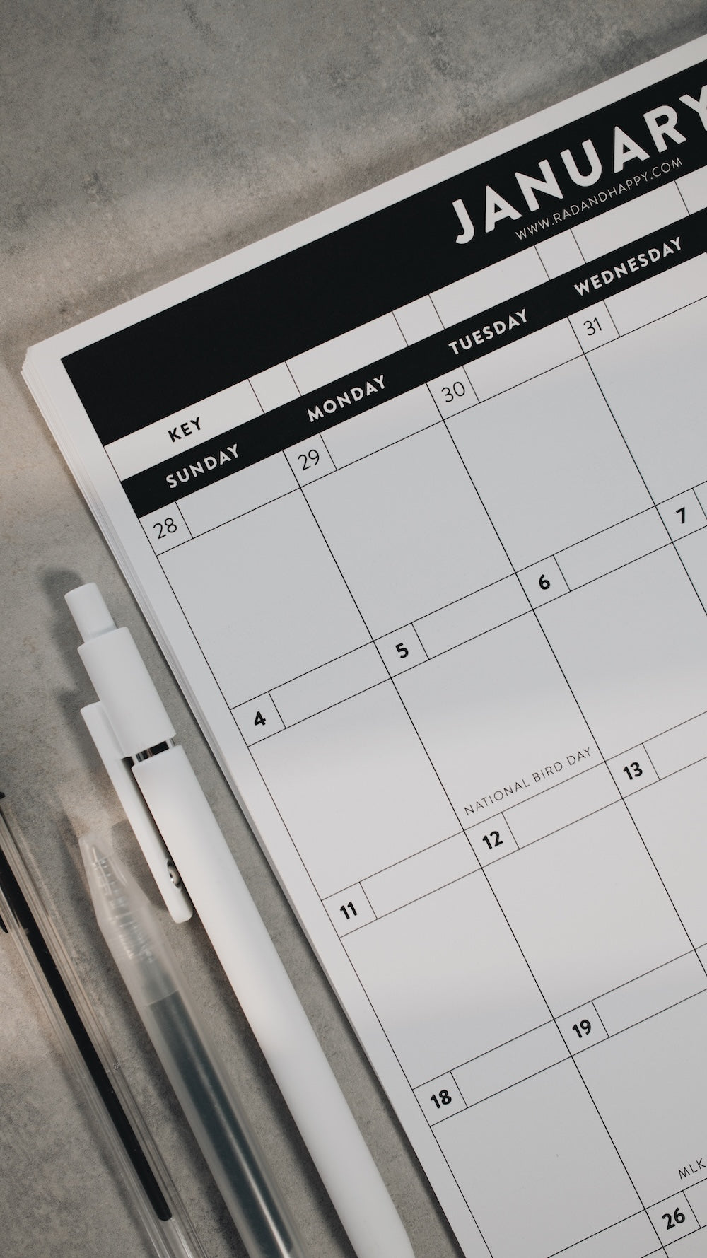 Calendar with a pen on a gray surface