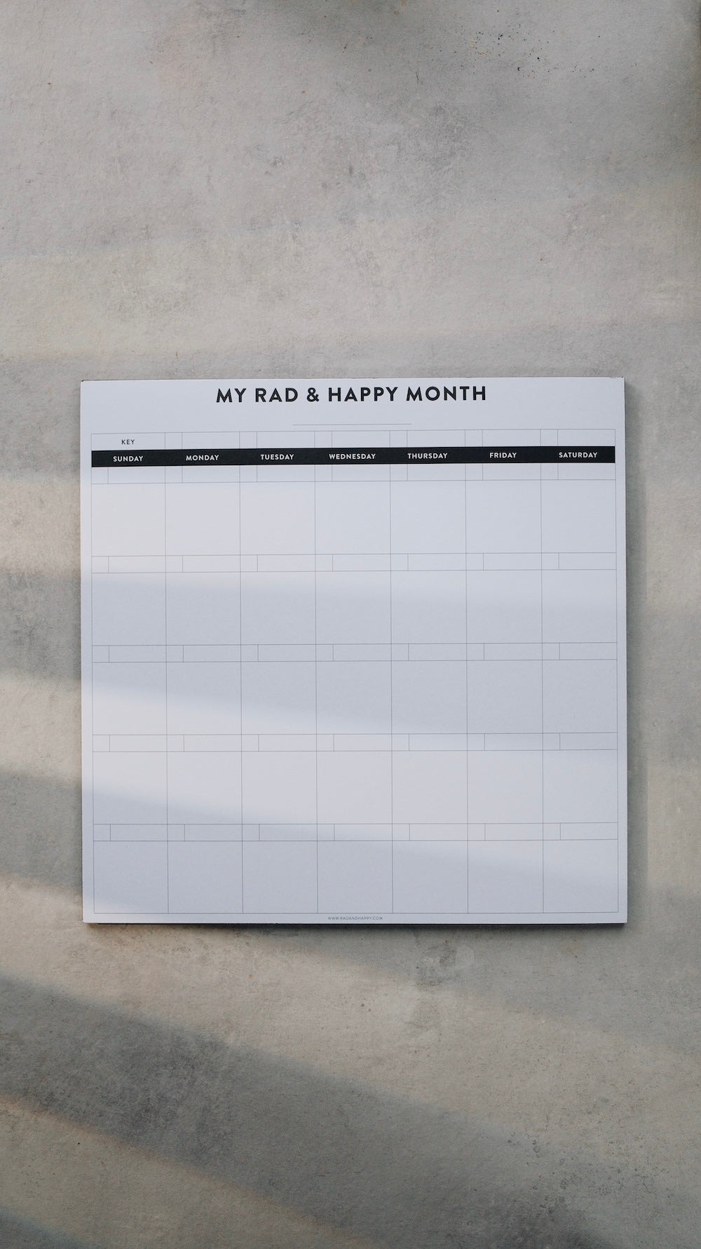 Monthly notepad with grid layout on a gray surface