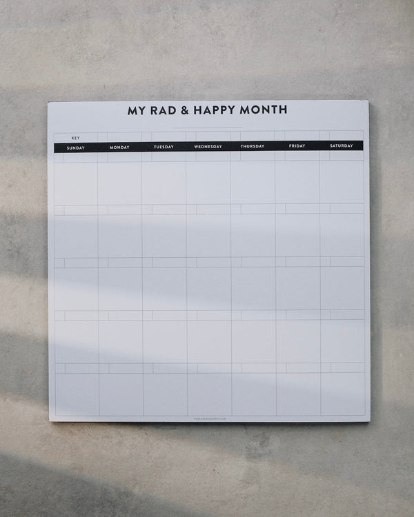 Monthly notepad with grid layout on a gray surface