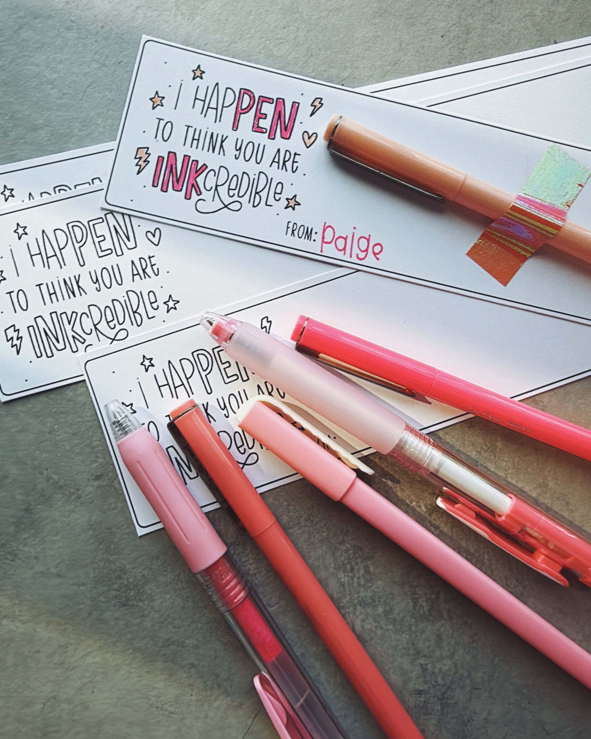 Colorful pens with personalized cards on a textured surface