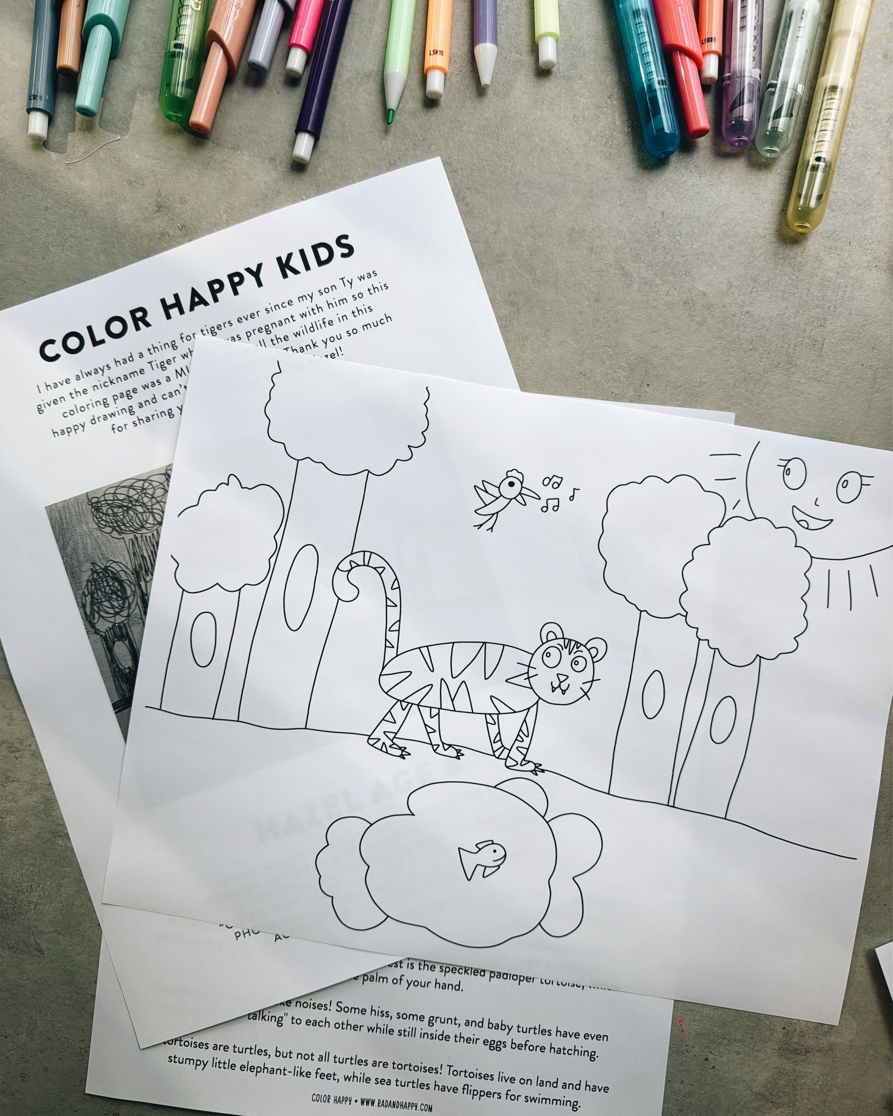 Coloring page with a tiger illustration and markers on a table