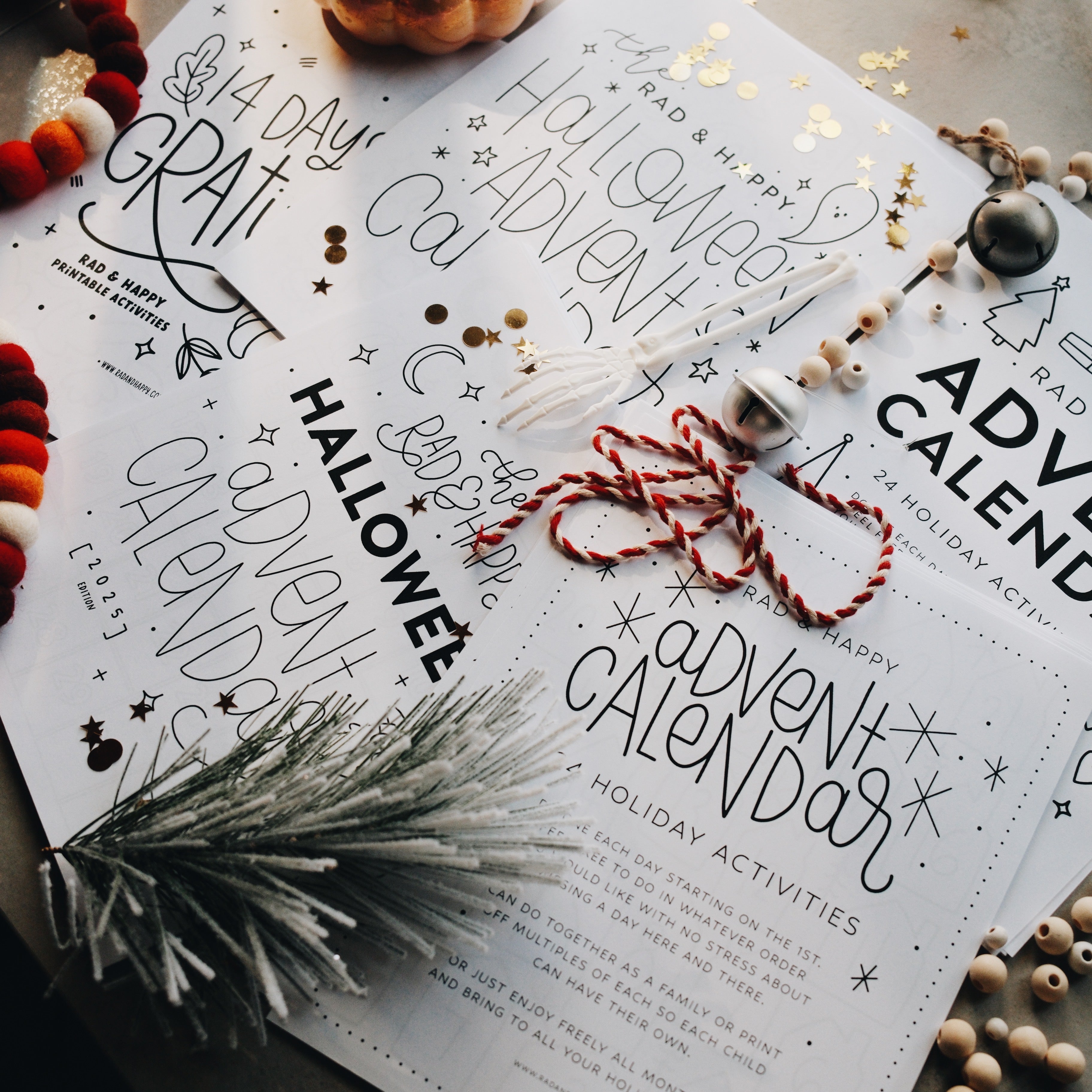Advent calendar pages laid out on a light gray surface with holiday decorations 