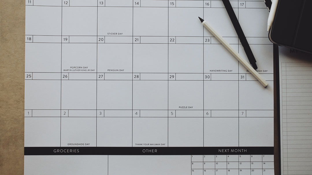 Pens laying on a calendar showing the bottom half of the page
