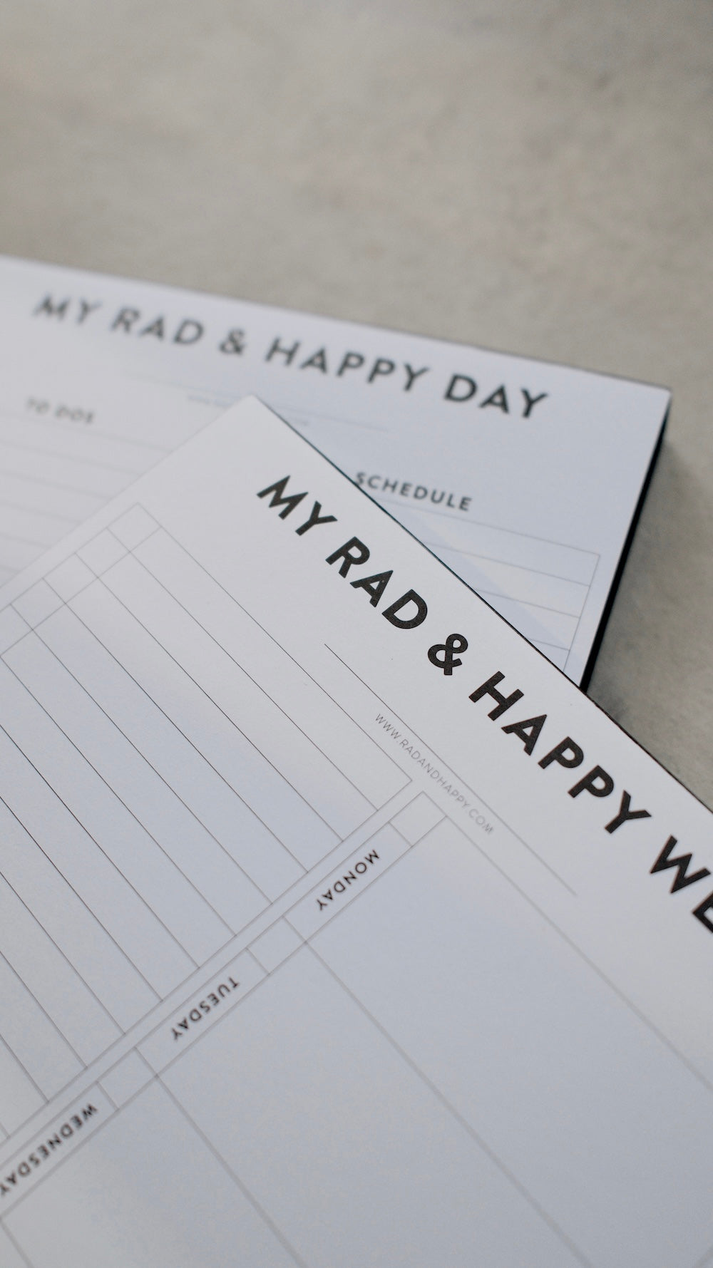 Two notepads with 'My Rad & Happy' branding on a light surface.
