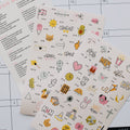 Two sheets of decorative stickers with various designs on a grid background