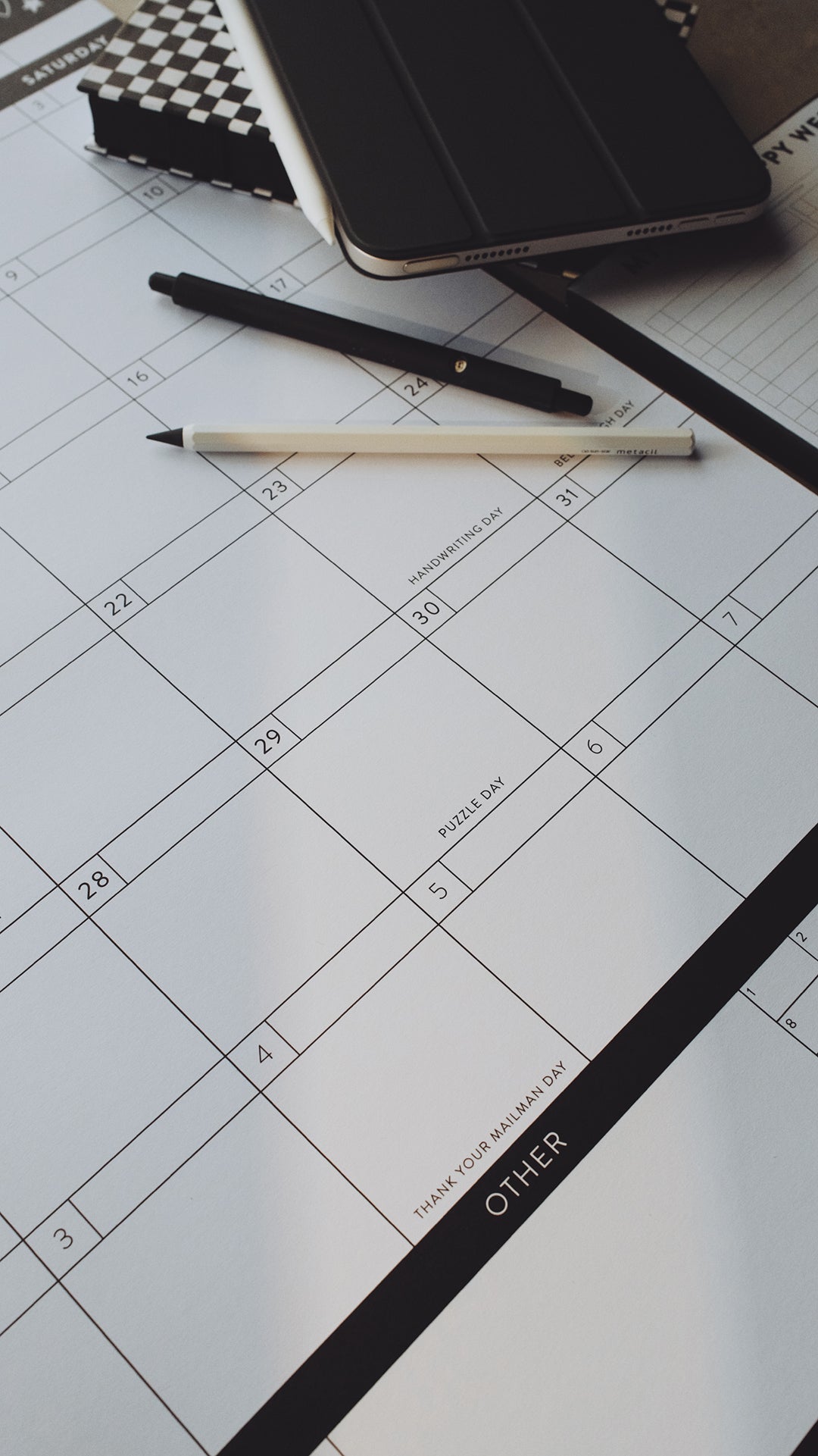 Pens and planner laying on a calendar page with the focus on a section titled "other"