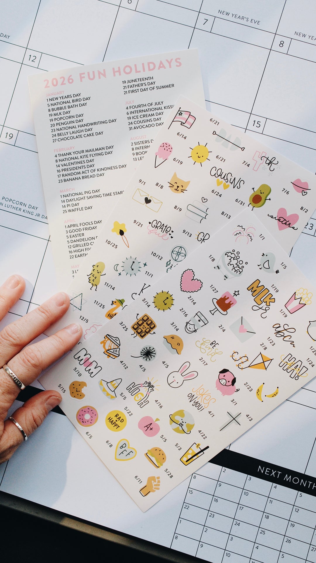 Sheet of stickers with various designs held over a planner.