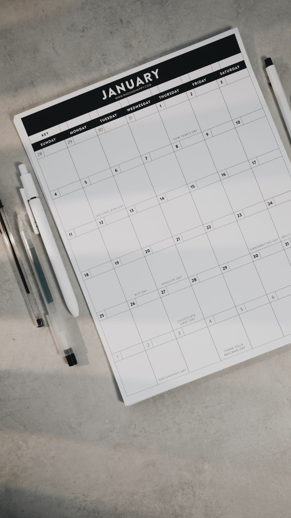 Calendar for January on a flat surface with pens beside it