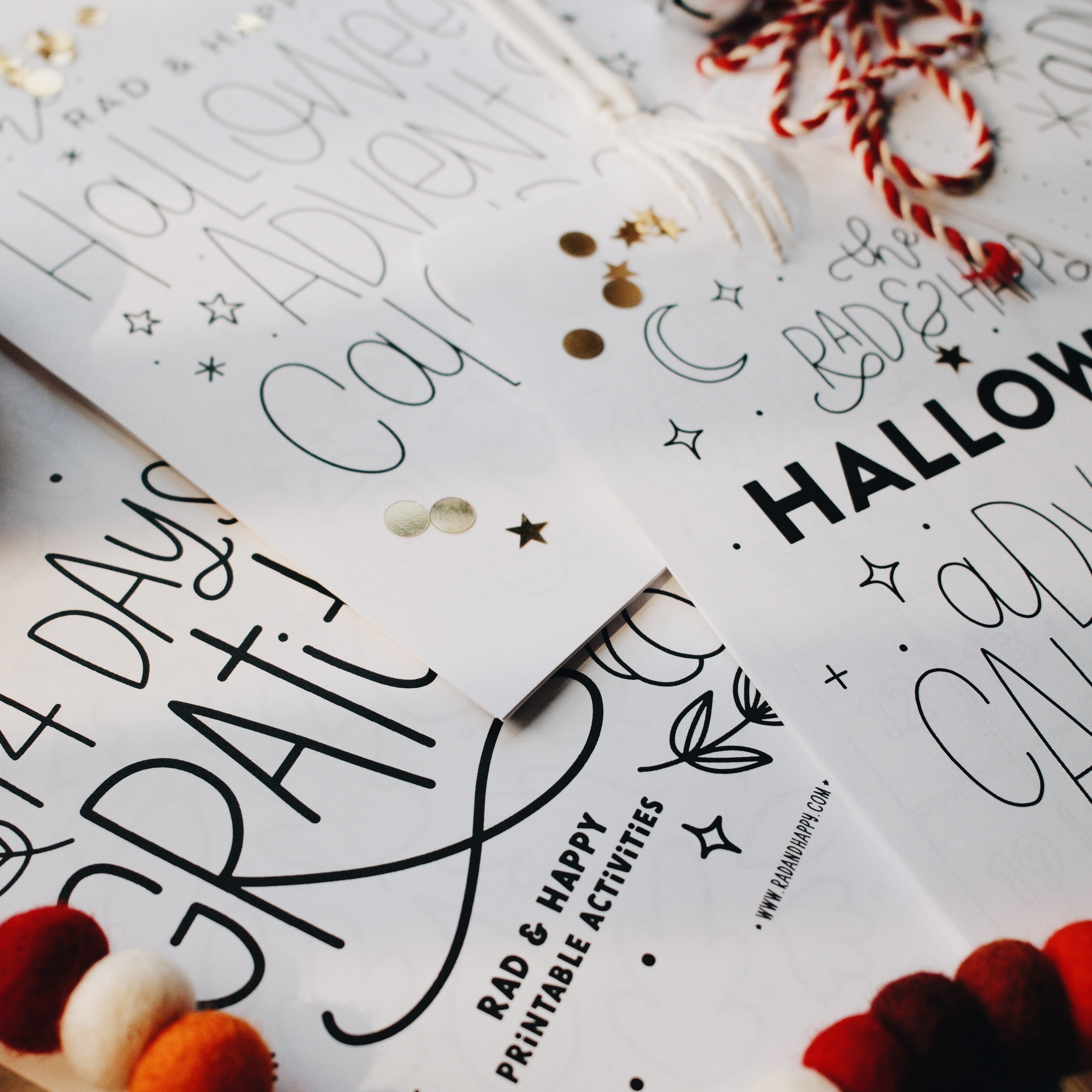 Bottom left corner of a Halloween advent page with a plastic skeleton hand on top of it