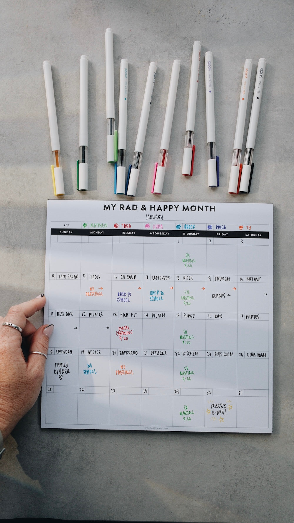 Month notepad with colorful markers on a gray surface