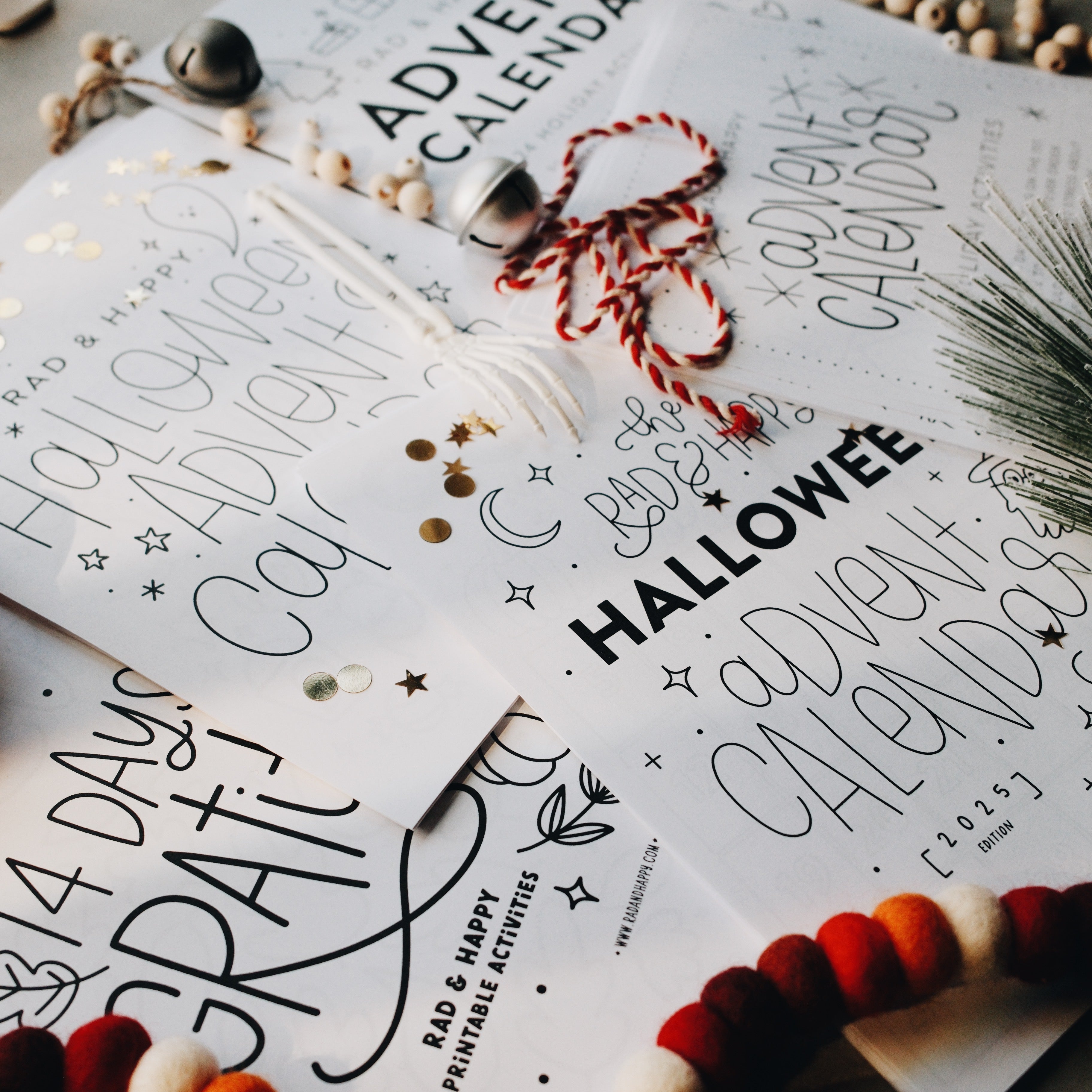 Advent calendar pages laid out on a light gray surface with holiday decorations 