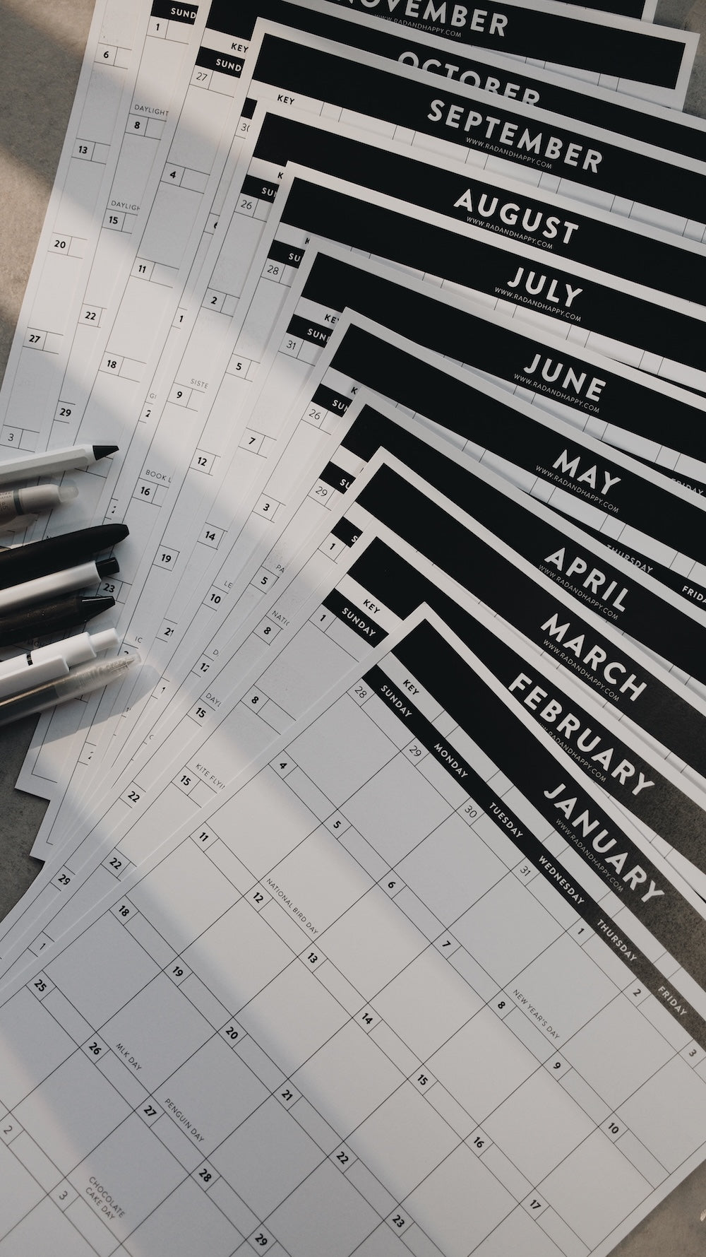 Calendar sheets with months printed on them, arranged on a flat surface.