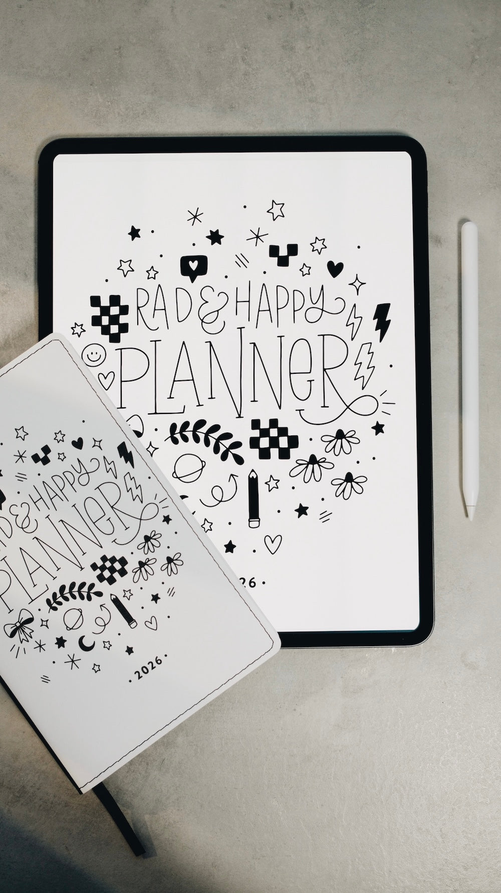 Two planners with decorative text and symbols on a gray surface