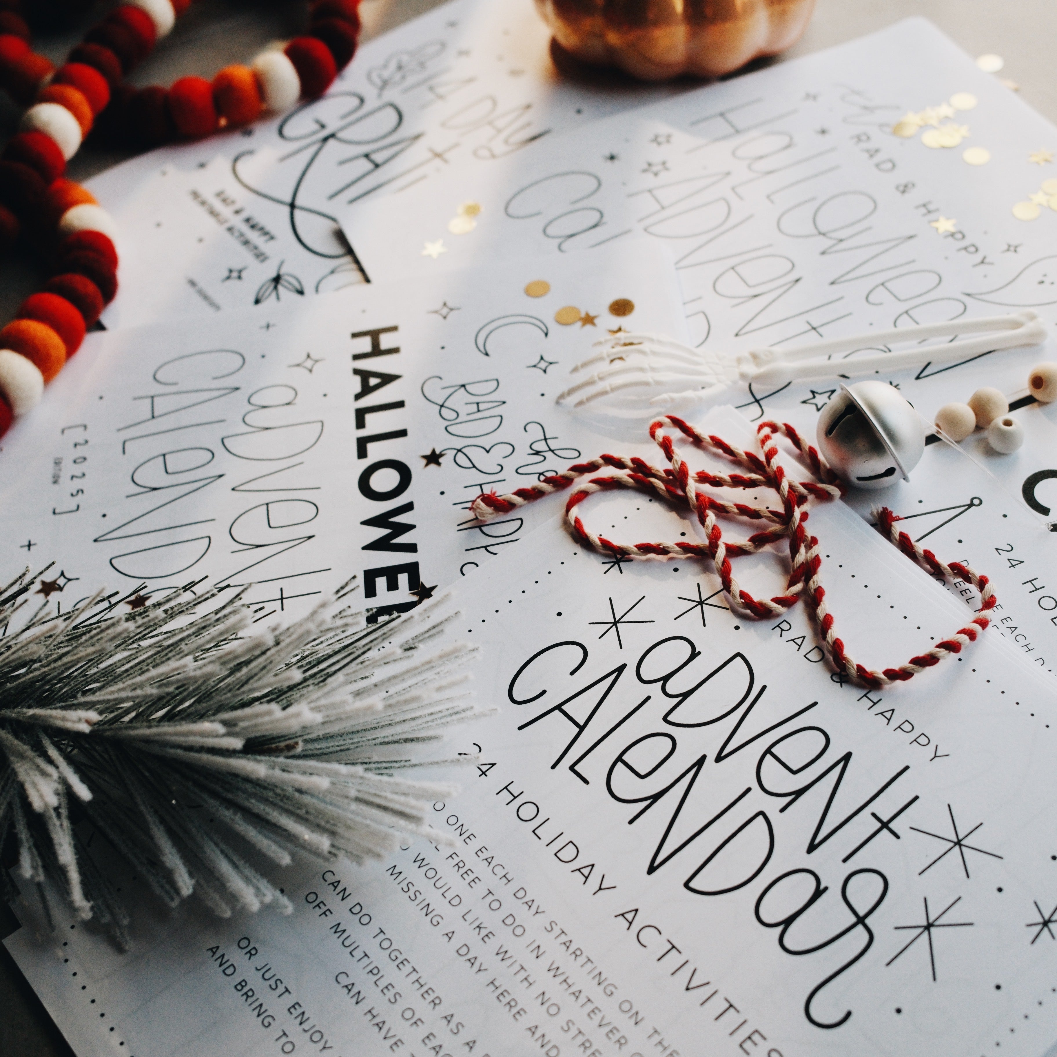 Advent calendar pages laid out on a light gray surface with holiday decorations 