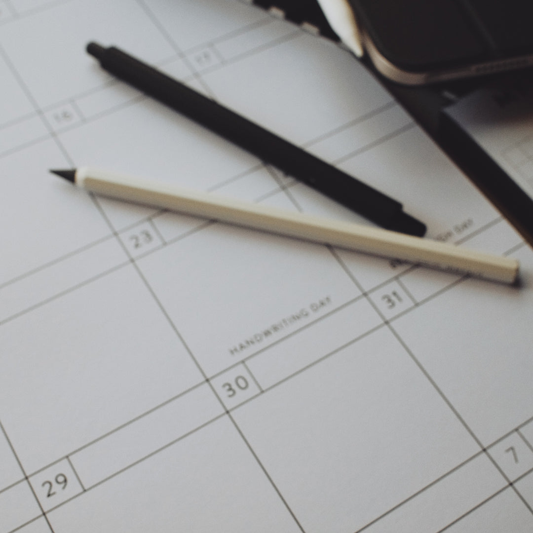 Black and white pens lying on a calendar page