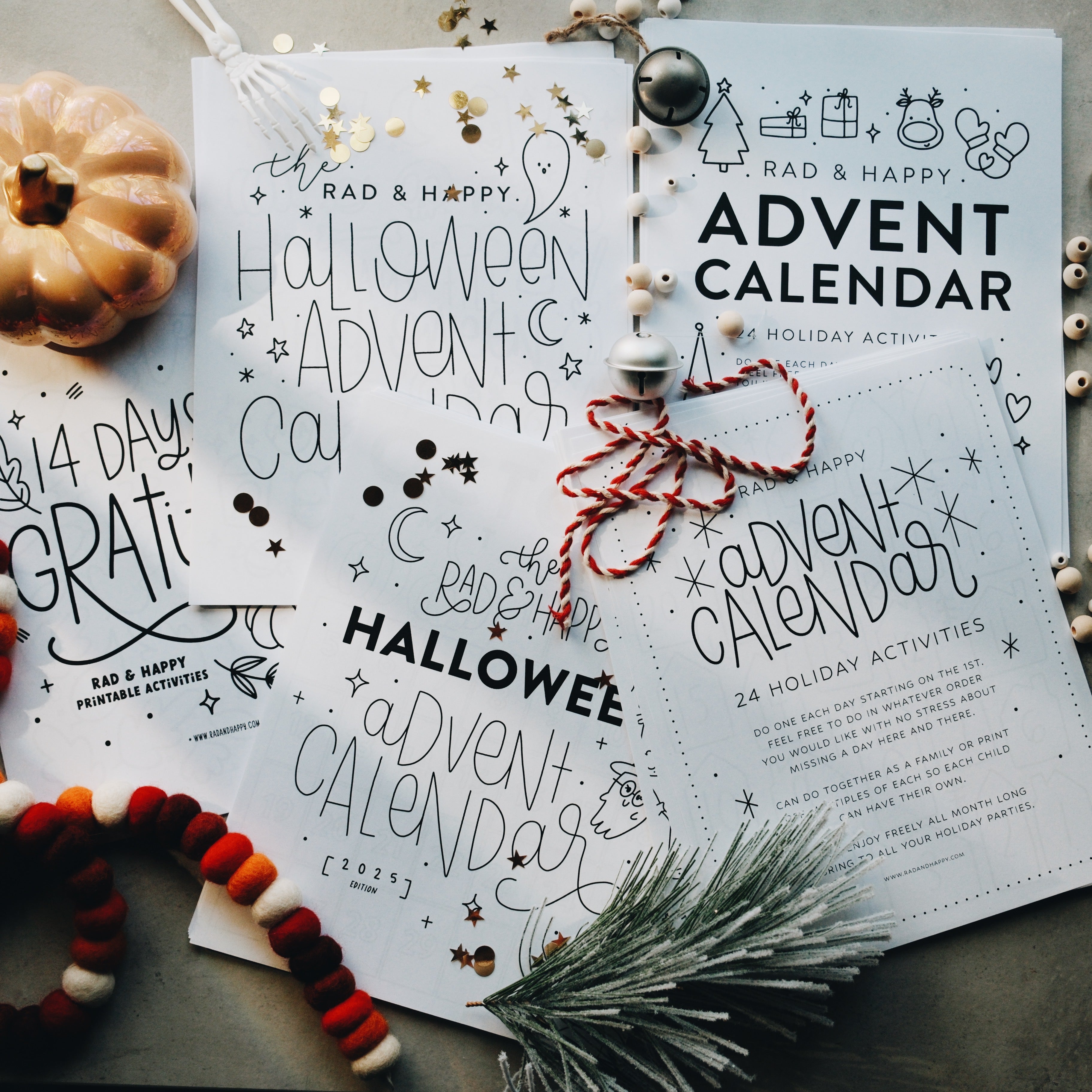 Halloween, Thanksgiving and Christmas Advent calendars laid out on a flat surface with holiday decorations touching each paper