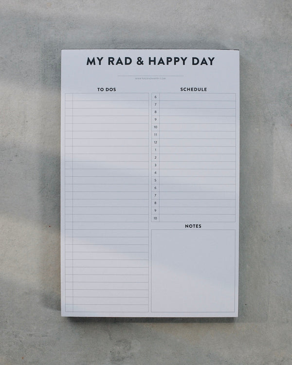 White notepad with black text on a gray concrete background