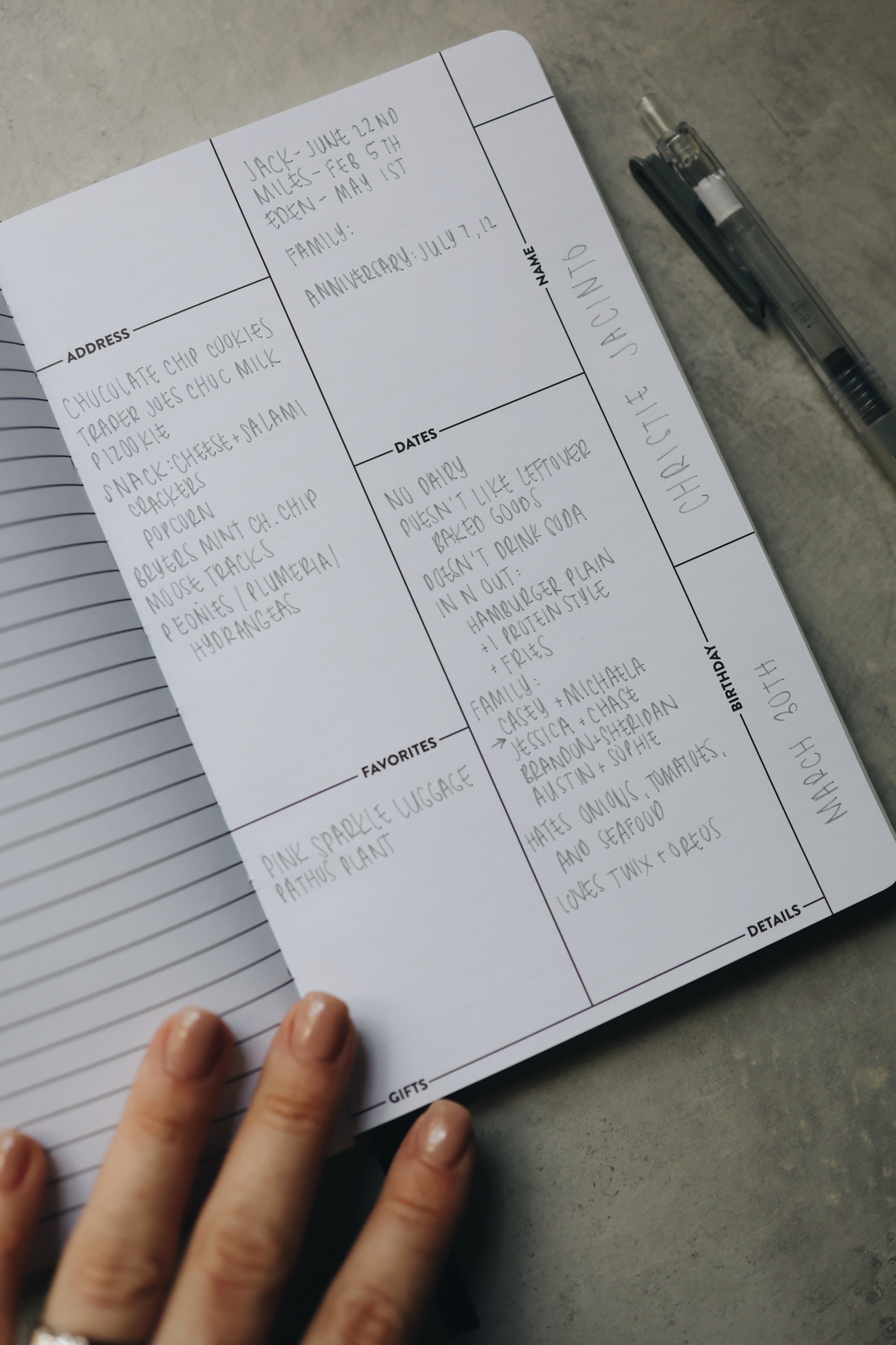 A hand holding the friendship journal open with handwriting on the page.
